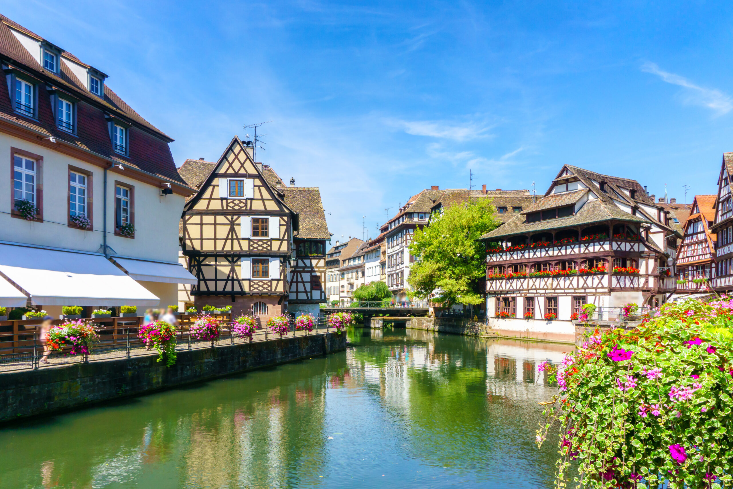 Strasbourg Petite France canal with flower-lined quays and half-timbered houses on a luxury Christmas wine tour in Alsace, France