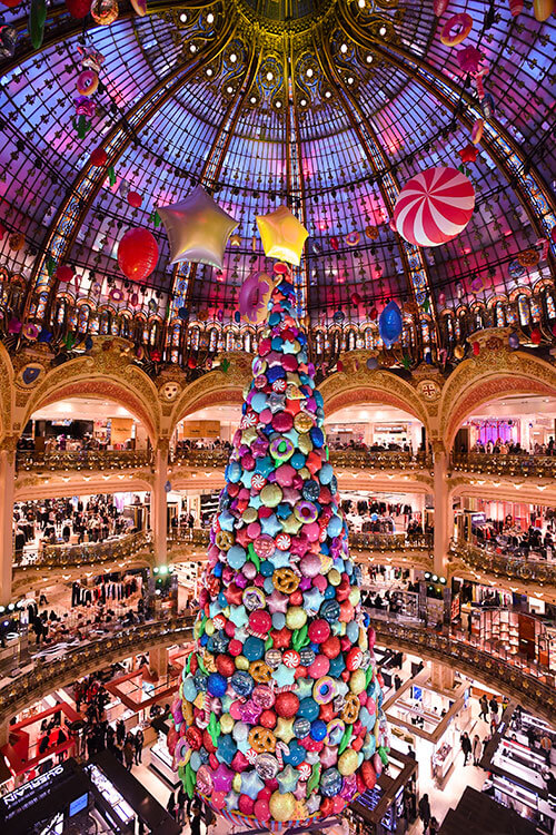 Giant colourful Christmas tree under the Art Nouveau stained glass dome of Galeries Lafayette department store, Paris, France