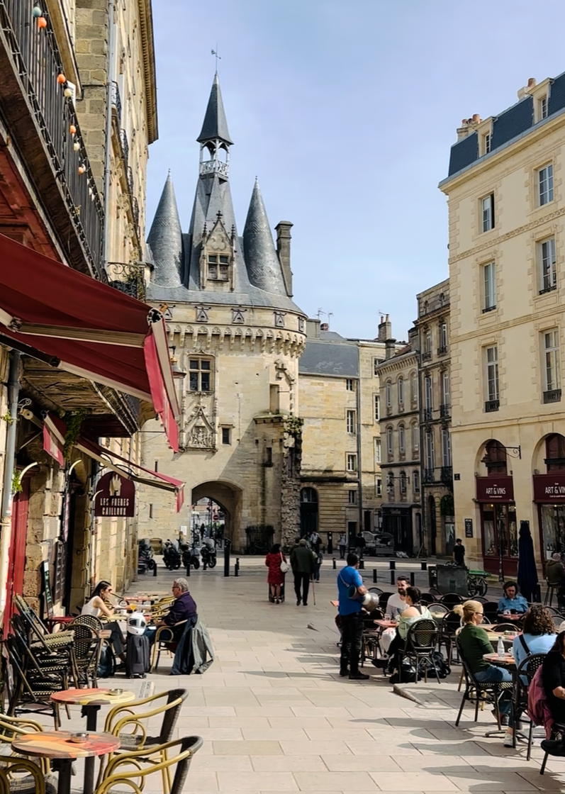 Porte Cailhau medieval gate and café terraces in Bordeaux old town on a luxury wine tour, France