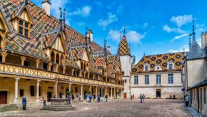 Hospices de Beaune courtyard with iconic multicoloured glazed tile roof on a luxury Burgundy wine tour, France