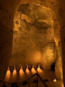 Ancient chalk cave cellar with Champagne riddling racks lit in warm amber light on a luxury Champagne wine tour, Reims, France