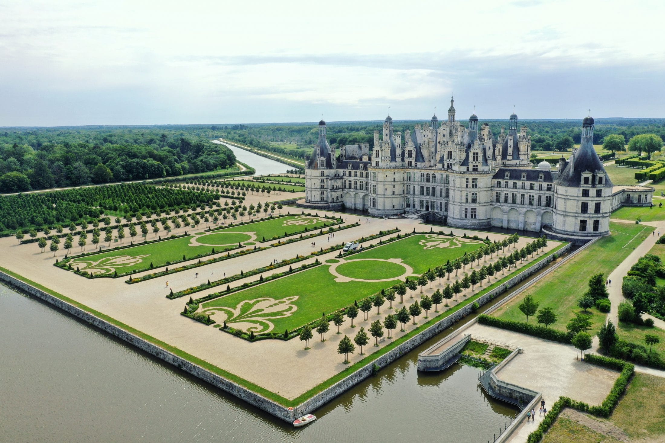 Aerial view of Château de Chambord with fleur-de-lis formal gardens and moat on a luxury Loire Valley wine tour, France