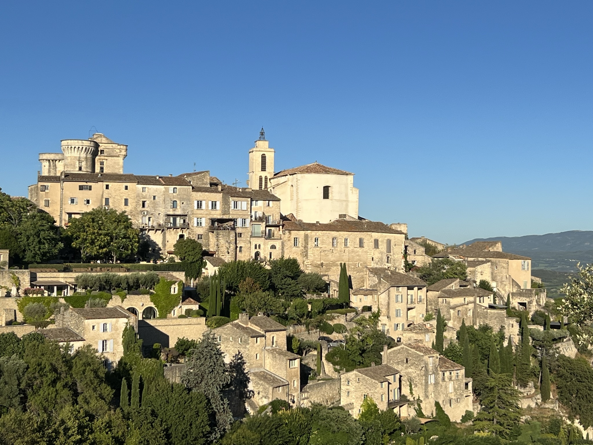 Gordes hilltop village with golden limestone buildings and cypress trees on a luxury Provence French Riviera tour, Luberon, France