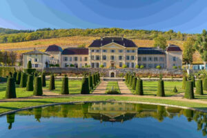 Beaujolais château with formal French gardens, topiary and autumn vineyards on a luxury Burgundy wine tour, France