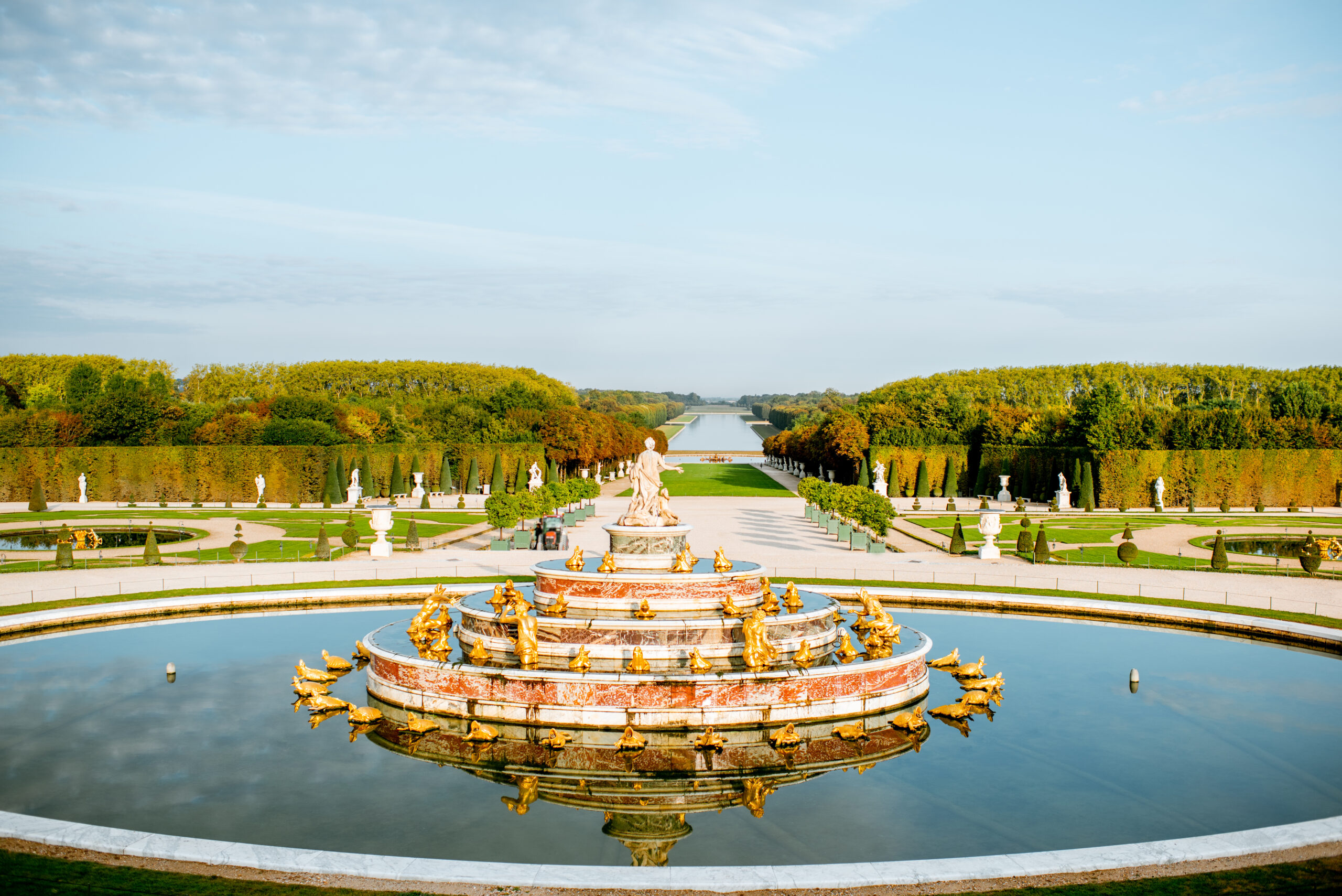 Latona Fountain with gilded sculptures in the formal gardens of the Palace of Versailles with Grand Canal view, France